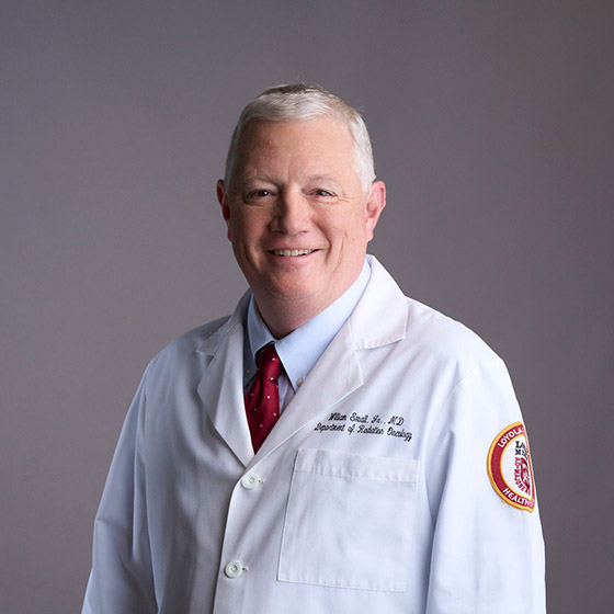 Dr. William Small, Jr., wearing his white lab coat